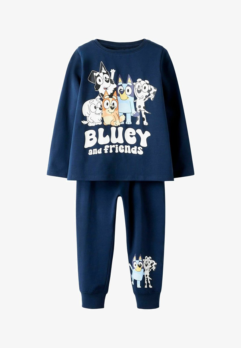 Ensemble de pyjama en coton bleu marine comprenant des manches longues, un motif de chiens de dessin animé et le texte "Bluey et ses amis". Pantalons assortis avec impression sur le côté.