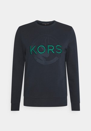 Navyblauwe longsleeve sweatshirt met ronde hals en verhoogd groen "KORS" logo boven een gestikt cirkelontwerp op de borst.