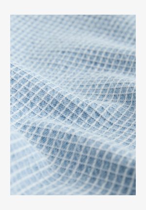 Light blue textured fabric with a grid pattern, featuring a soft, woven surface and subtle shading variations.