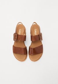 Brown leather sandals with two wide straps and a side buckle, featuring a cushioned tan insole and textured sole for grip.