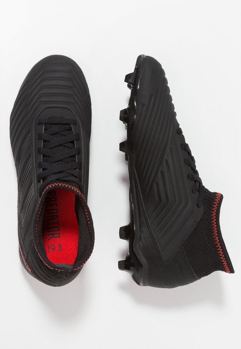 Pair of black soccer cleats with textured design, red interior sole, laces, and padded ankle collar on a white background.
