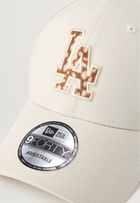 Bežna kapa z vezenim rjavim logotipom LA. Ima strukturirano obrobo in srebrno oznako "9FORTY ADJUSTABLE" podjetja New Era.