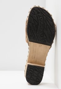 Semelle d'une chaussure sabot taille 37 avec une bande de roulement en caoutchouc noir, une semelle intermédiaire en bois et des clous en métal sur les côtés.