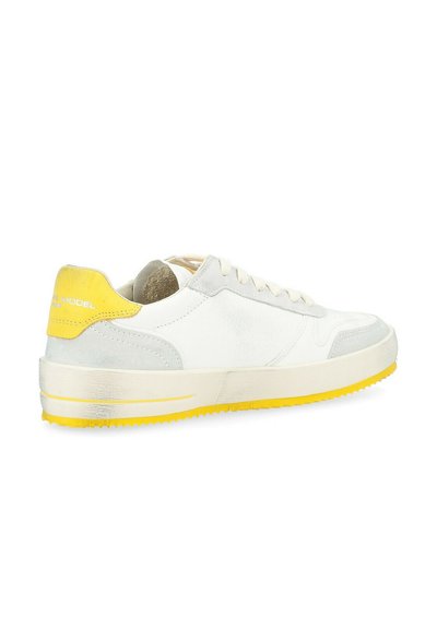 Sneaker in pelle bianca con dettagli grigi, tallone e suola gialli, chiusura con lacci piatti, tomaia texturizzata e finitura liscia. Design con punta arrotondata.
