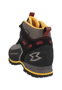 Botas de senderismo de ante negro con acentos grises y suela amarilla. Presentan costuras rojas, un collar acolchado y una práctica asa.