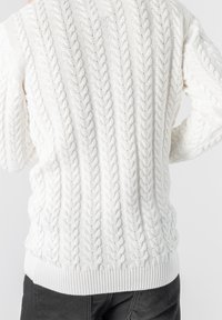 Maglione bianco a treccia caratterizzato da un motivo testurizzato con trecce in rilievo, polsini a coste e un orlo inferiore a fascia. Materiale in maglia leggero.