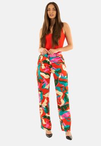 Pantaloni a gamba larga multicolori caratterizzati da un vivace motivo floreale astratto nei colori rosso, rosa, verde e blu, con vita alta e tessuto morbido.