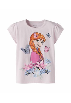 Lichtroze kindershirt met een illustratie van een roodharig meisje omringd door vlinders en diverse bloemen in pasteltinten.