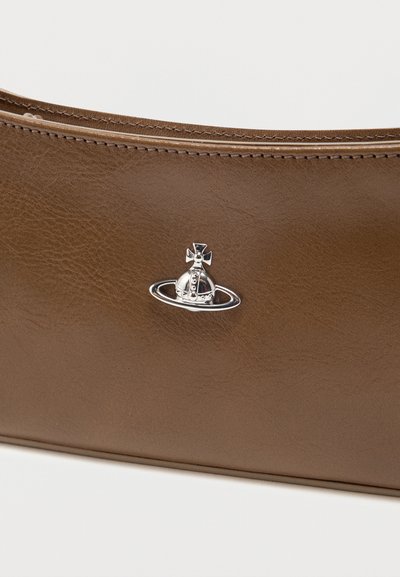 Barna bőr táska részletes varrással és egy kis ezüst gömb és gyűrű emblémával a középen, az elülső felületen.