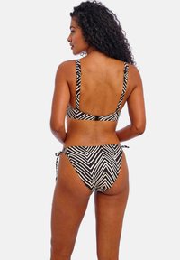 Black and white zebra-striped bikini featuring a supportive top with wide straps and a bottom with adjustable ties, showcasing a smooth texture.