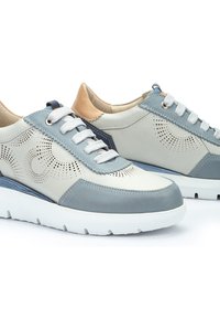 Zapatillas de cuero azul claro y gris con diseño perforado, suela de goma blanca y acentos en contraste de azul marino y marrón. Cierre con cordones.