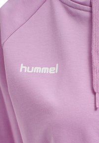 Ljuslila hoodie med texturerad tyg, vit "hummel" logotyp och dragsnöre med flätad design i huvan.