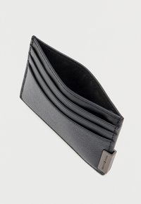 Portafoglio in pelle nera con tre slot per carte e un compartimento centrale, dotato di un'etichetta metallica con il logo del marchio in un angolo.