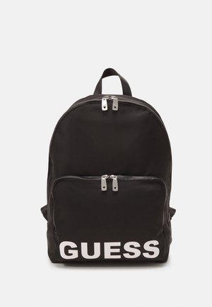 Zwarte nylon rugzak met het witte "GUESS" logo. Heeft een voorkant met ritsvak en dubbele ritslussen. Rond ontwerp met gewatteerde schouderbanden.