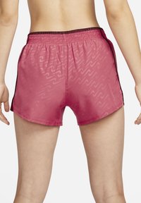 Short pink shorts with a wave pattern, elastic waistband, and black side accents; lightweight, smooth texture.