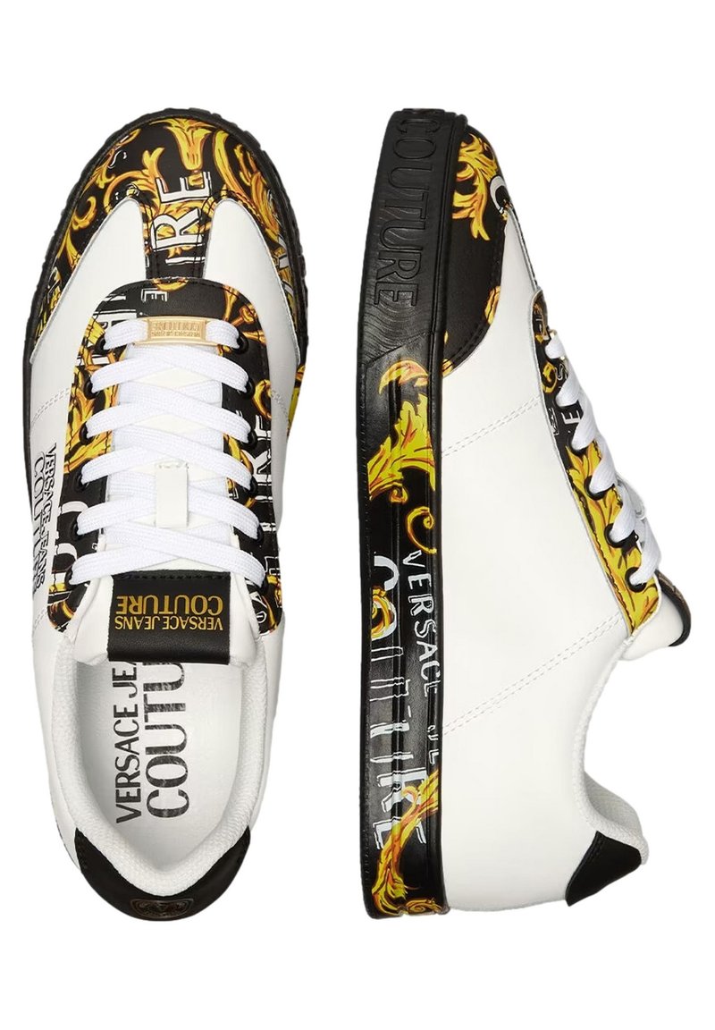 Baskets basses blanches avec des motifs baroques noirs et dorés, des lacets blancs, et un logo "Versace Jeans Couture" sur les côtés, la languette et la semelle.