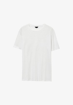 T-shirt bianca a maniche corte con collo tondo, con un piccolo etichetta nera del marchio all'altezza del collo su uno sfondo bianco.