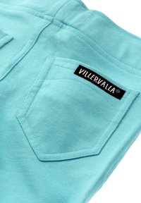 Türkisfarbene Baumwollhosen mit zwei Gesäßtaschen. Mit einem schwarzen Etikett, auf dem der Text "VILLERVALLA" gestickt ist. Glatte Textur und lässiges Design.