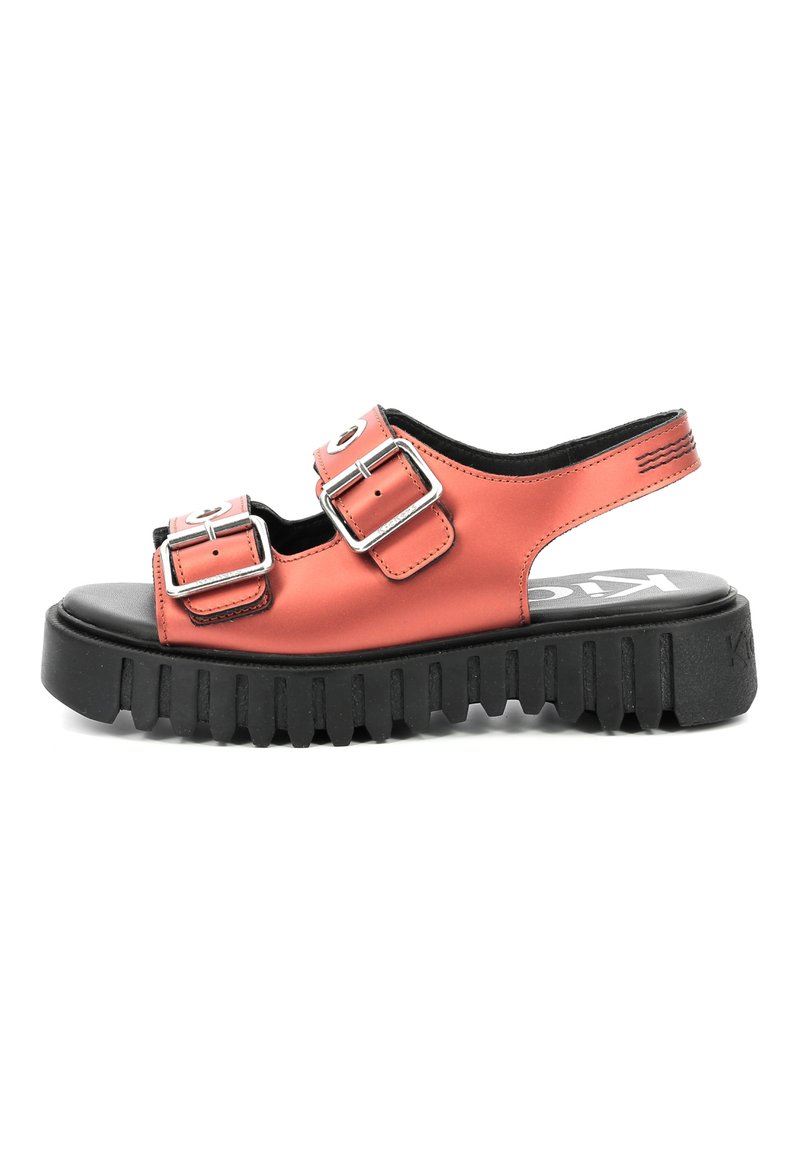 Sandalia tipo slide sintética en color coral, con dos hebillas plateadas, una suela gruesa y estriada en negro, y un talón abierto para facilitar el uso.