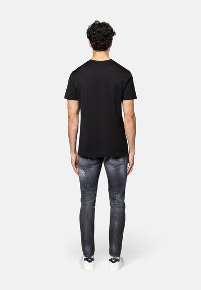 Zwarte t-shirt met korte mouwen en een ronde hals, gecombineerd met vervaagde grijze spijkerbroeken met subtiele slijtage details en een strakke pasvorm.