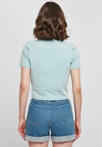 Merchcode LILO & STITCH SITTING ON FLOWER CROPPED - T-shirts med print - oceanblue