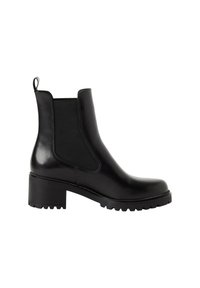 Bottine Chelsea en cuir noir avec panneaux latéraux élastiques, talon bas et épais, languette à l’arrière et semelle à crampons robuste.