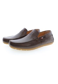 Bruna läderslippers med stickad detalj, en slät textur, gummisula och en liten accenttagg med röd, vit och blå.