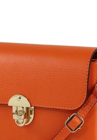 Oranje leren handtas met een gestructureerde afwerking, voorzien van een gouden metalen sluiting en een verstelbare band. Rechthoekige vorm met gestikte randen.