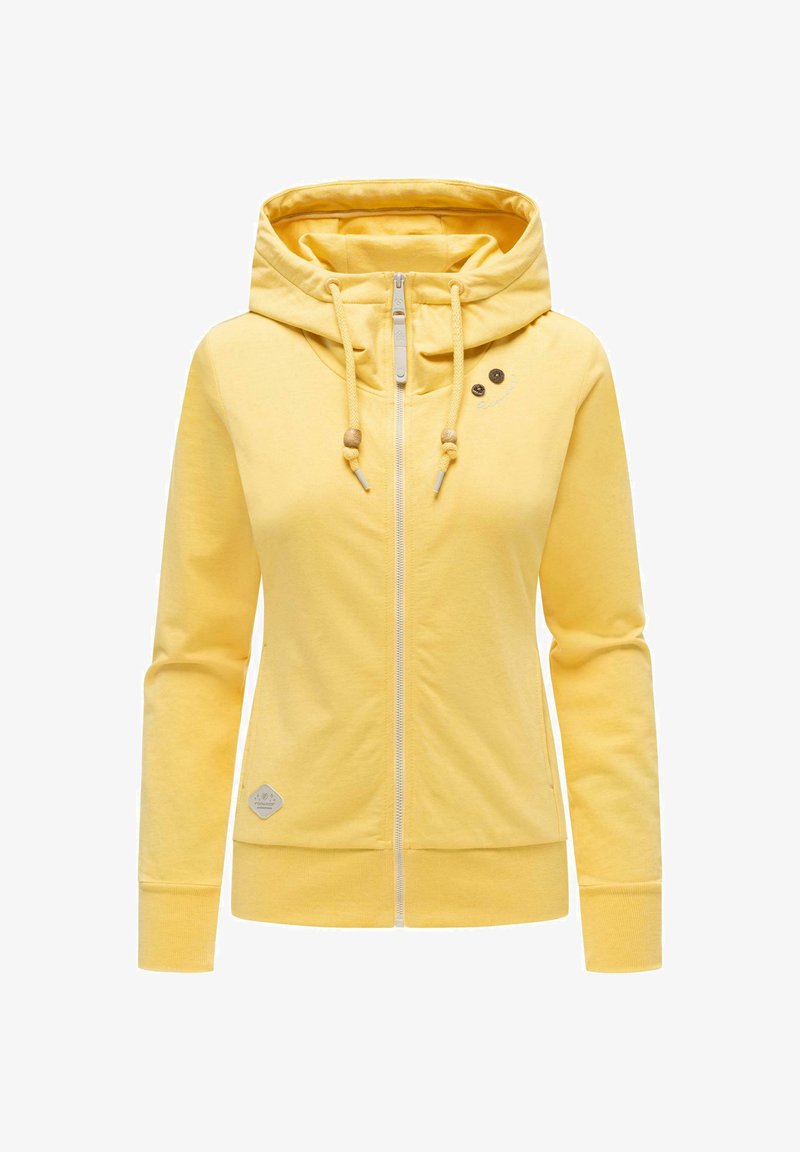 Gul hettejakke med glidelås, stor hette, snorer med tresperler, lange ermer og ribbestrikkede mansjetter og kant.