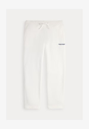 Białe spodnie dresowe ze sznurkiem w pasie, z napisem "POLO SPORT" na niebiesko na lewej udzie. Miękka tkanina i prosty krój nogawek.