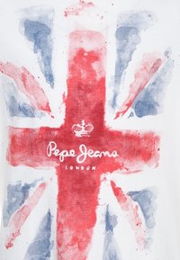 Bílý tričko má design vlajky Spojeného království v červené a modré akvarelové stylu, s nápisem "Pepe Jeans London" vytištěným uprostřed tučným písmem.