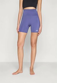 Korkeavyötäröiset purppuranväriset urheilushortsit, joissa on sileä pinta ja vasemmassa reidessä pieni valkoinen logo.