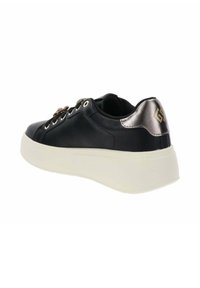 Baskets en cuir noir avec une semelle blanche épaisse, accent en métal au talon, bout rond, lacets décoratifs et petit logo sur l'arrière.