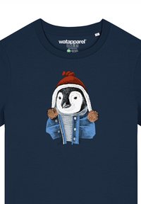 Marineblauwe t-shirt met een illustratie van een pinguïn die een rood hoedje en een blauwe spijkerjack met bruine pomponaccenten draagt.