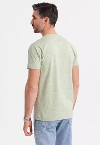Lichtgroene T-shirt met korte mouwen met een gestructureerd patroon, gemaakt van zachte stof, met een klassieke ronde hals en een ontspannen pasvorm.