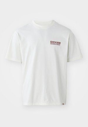 Valkoinen puuvillapaita, jossa on lyhyet hihat, pyöreä kaula-aukko ja punainen logo vasemmassa rinnassa. Yksinkertainen muotoilu ilman kuvioita.