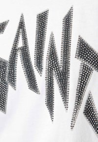 T-shirt bianco in cotone con lettering in strass argentati dal design frastagliato, con una finitura testurizzata e pietre di varie dimensioni.