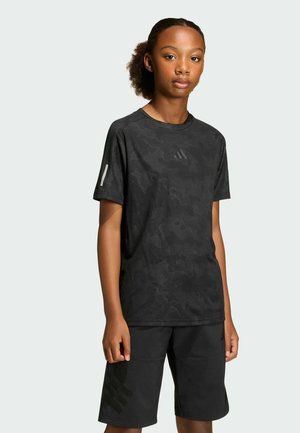 Black athletic t-shirt with camouflage pattern and reflective logo. Paired with black shorts featuring a subtle logo design. Smooth fabric texture.