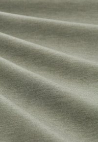 Lichtgroene stof met een gladde textuur, voorzien van zachte plooien en subtiele schakeringen, wat duidt op een lichtgewicht materiaal.