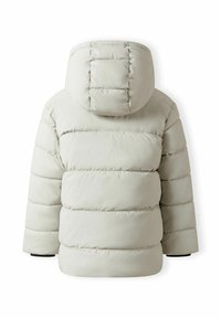 En lätt beige puffjacka med huva, horisontell quiltning och elastiska ärmmuddar. Slät, vadderad textur utan synlig hårdvara.