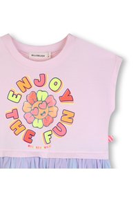 Ροζ βαμβακερό τοπ με κοντά μανίκια, διακοσμημένο με πολύχρωφο γραφικό "Απόλαυσε τη Διασκέδαση" και στρώσεις μωβ τούλι στη φούστα στο τελείωμα.