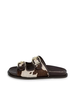 Brown leather slide sandals with cowhide accent, featuring two adjustable buckles. Flat sole and open design for easy wear.