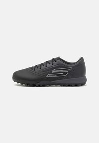Chaussures de sport noires avec un dessus texturé, un design à lacets et une semelle en caoutchouc dotée de multiples crampons pour l'adhérence. Logo accentué sur le côté.