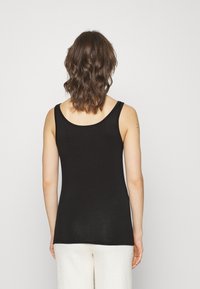 Black tank top with a scoop neckline, made of ribbed material. The back is smooth, fitted, and features narrow shoulder straps.