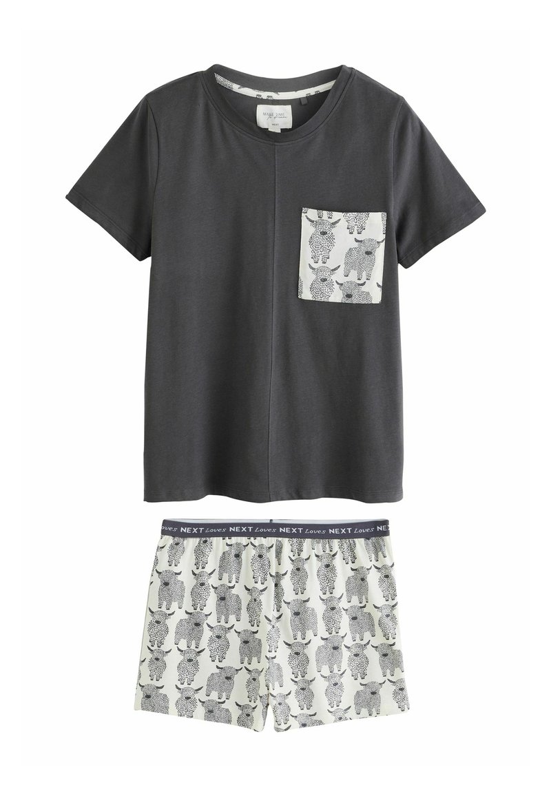 Grijze katoenen t-shirt met korte mouwen en een geborduurde zak, gecombineerd met crèmekleurige shorts met zwarte koeienillustraties en een marineblauwe tailleband.