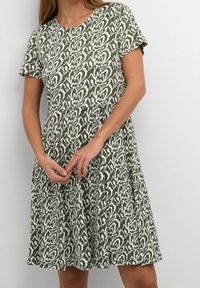 Sukienka z krótkim rękawem w zielono-białym kolorze z kwiatowym wzorem, z okrągłym dekoltem, luźnym krojem i zwiewnym dołem.