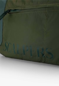 Grüne Stofftasche mit einem Reißverschlusstasche und dem "SCALPERS"-Logo in Dunkelgrün. Glatte Textur mit Nähdetails.