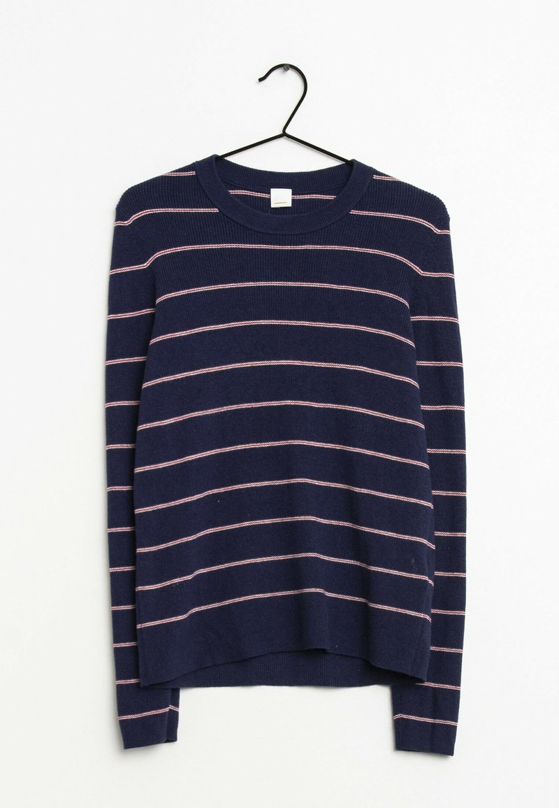 Pull en maille bleu marine avec des rayures horizontales roses, encolure ronde, manches longues et un ourlet arrière légèrement allongé. Suspendu à un crochet noir.