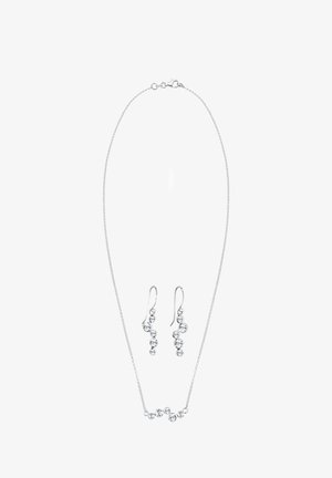 Silberfarbene Halskette und passende Ohrringe mit klaren Kristallakzenten. Die Halskette hat eine zarte Kette mit einer Reihe von fünf Kristallen.