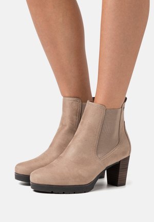 Beige Wildleder-Ankle Boots mit elastischen Seitenpanelen, einer abgerundeten Zehe und einem strukturierten Holzblockabsatz. Gummisohle für besseren Halt.